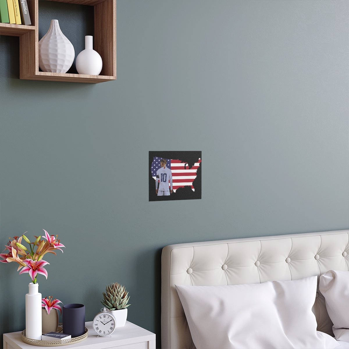 Front view of Christian Pulisic in USMNT kit in front of USA themed background of flag inside country outline poster hanging above bed.