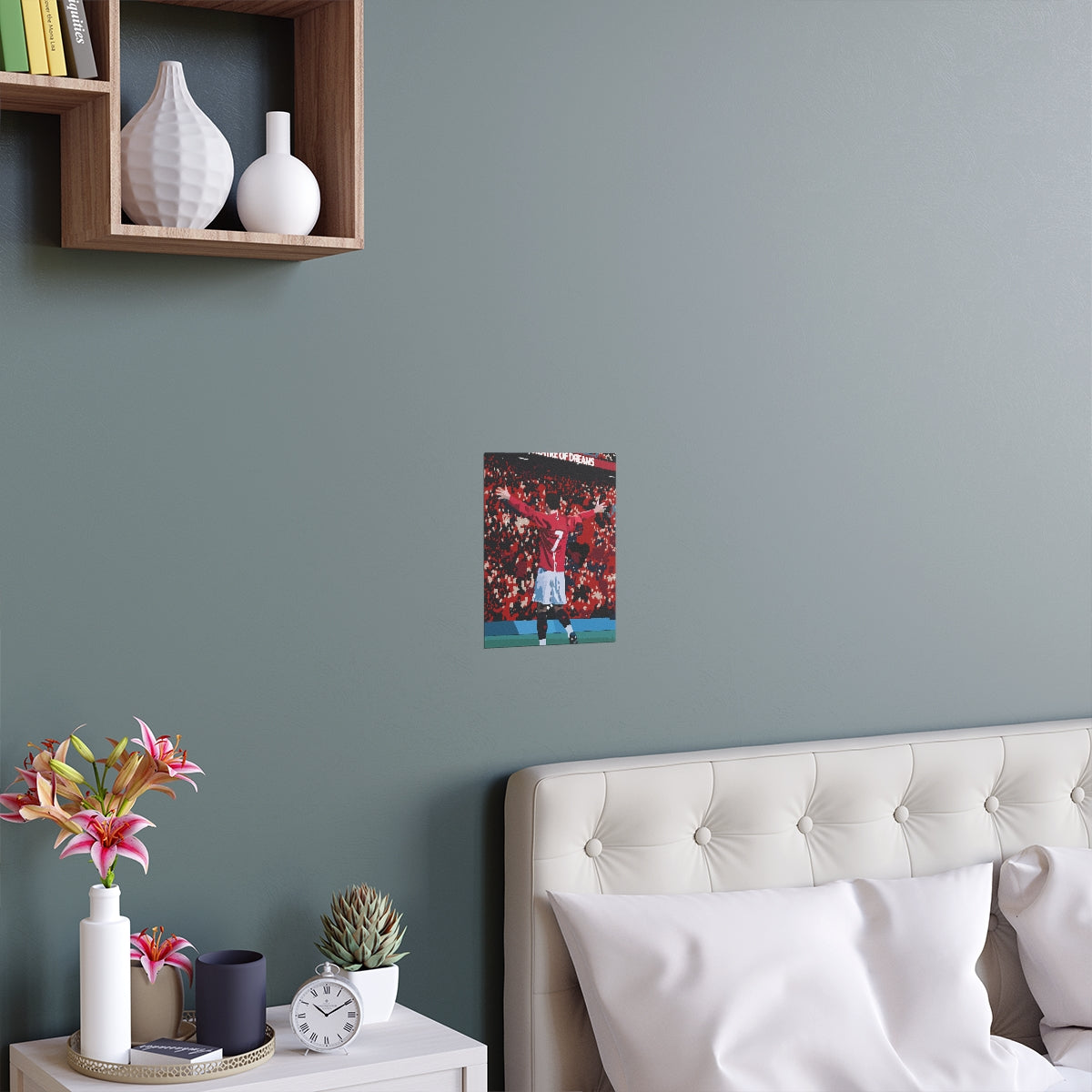 Contextual Front view of Manchester United Cristiano Ronaldo celebrating in front of Old Trafford crowd on a poster hanging above a double bed.