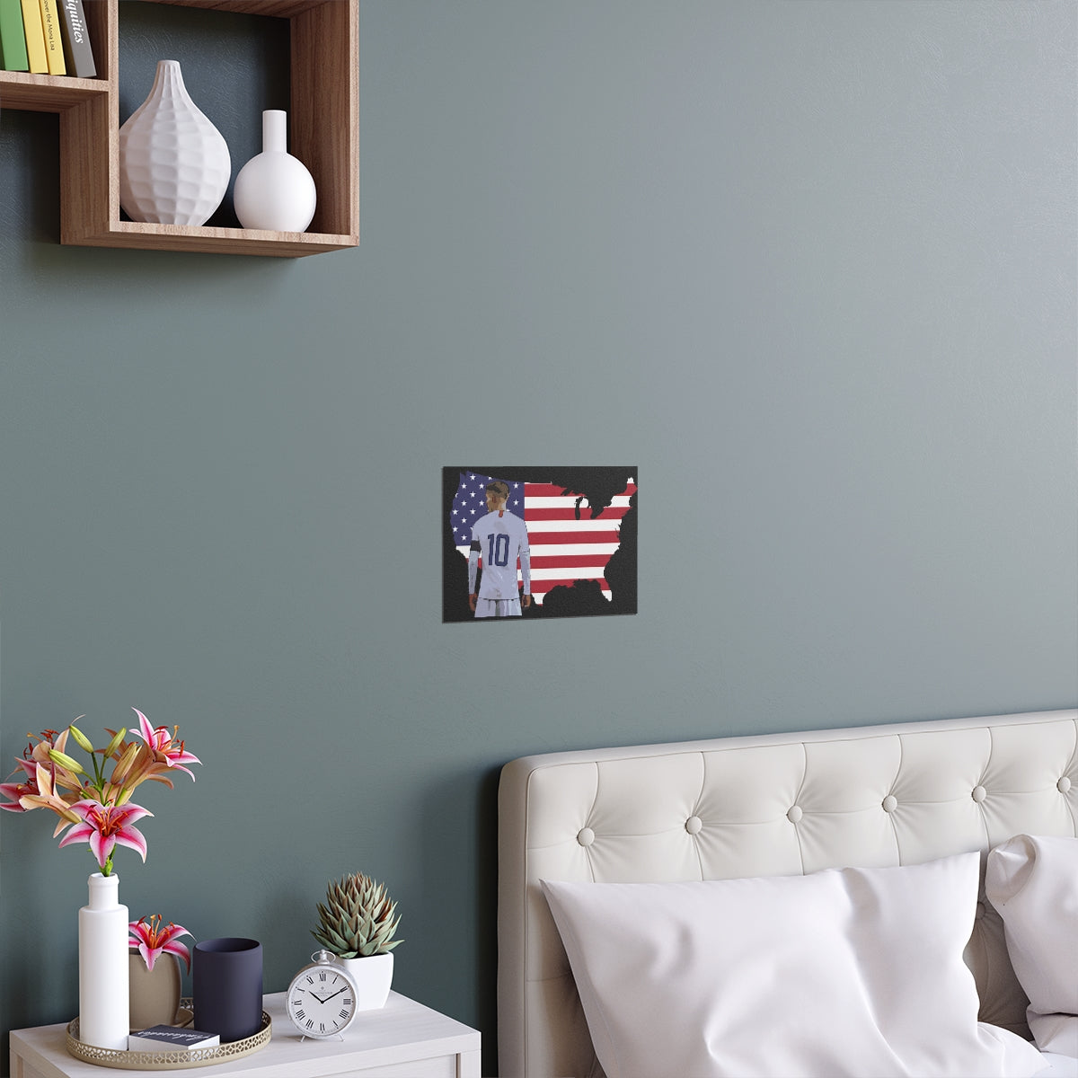 Front view of Christian Pulisic in USMNT kit in front of USA themed background of flag inside country outline poster hanging above bed.