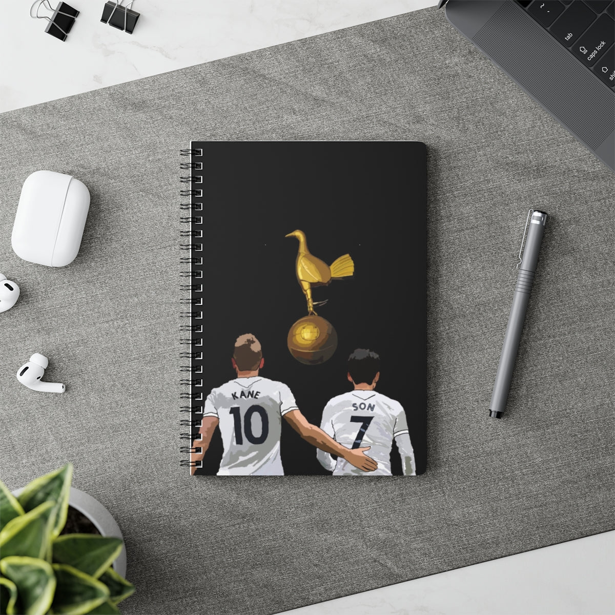 Contextual Front view of Harry Kane and Heung-Min Son with a gold cockrel on a black background on a black A5 spiral notepad.